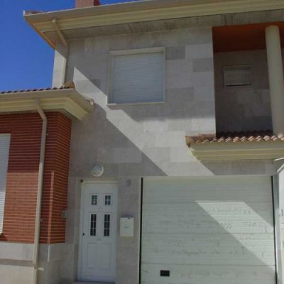 Fachada de una de las viviendas con los acabados de puerta de entrada y puerta de garaje de16 viviendas unifamiliares Íscar